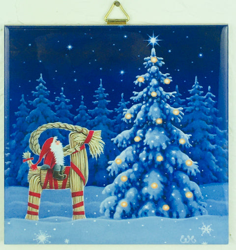 A festive illustration titled "Tile: Tomte on Straw Goat Julbok 6" Ceramic" by Eva Melhuish showcases a Santa figurine perched on a straw goat near a decorated, snowy Christmas tree, all set against a starry night sky and elegantly framed with a triangular brass hanger.