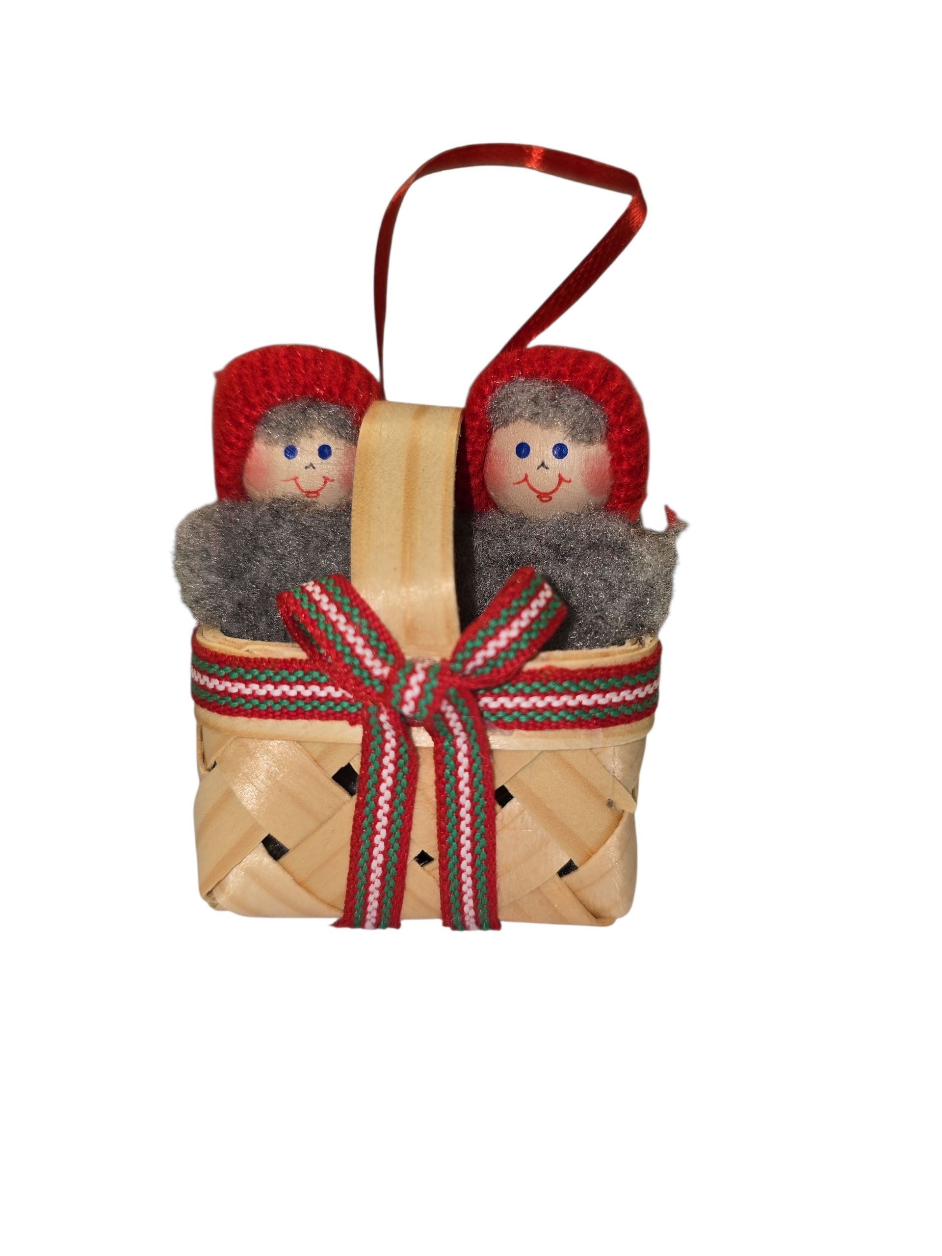 Ornament: Swedish Santa Figurines in a Basket—two hand-painted Santas with red knit hats and gray scarves, arranged in a small woven basket trimmed with a decorative ribbon for a charming Christmas touch.