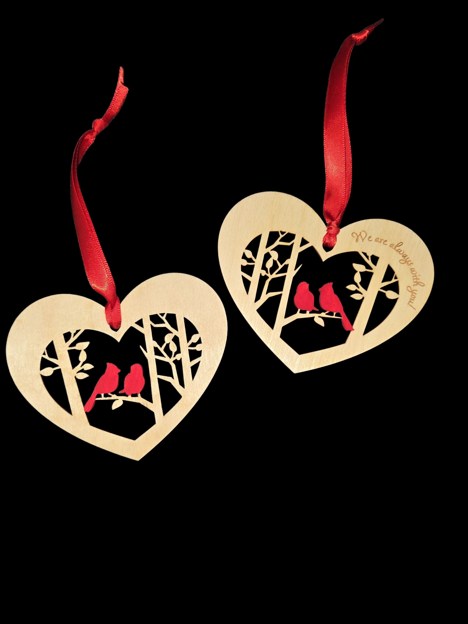 This laser cut wood heart-shaped ornament features 2 cardinals on a branch and is engraved with “We are Always with You”—a beautiful holiday decor piece for your Christmas tree. Red ribbon included.