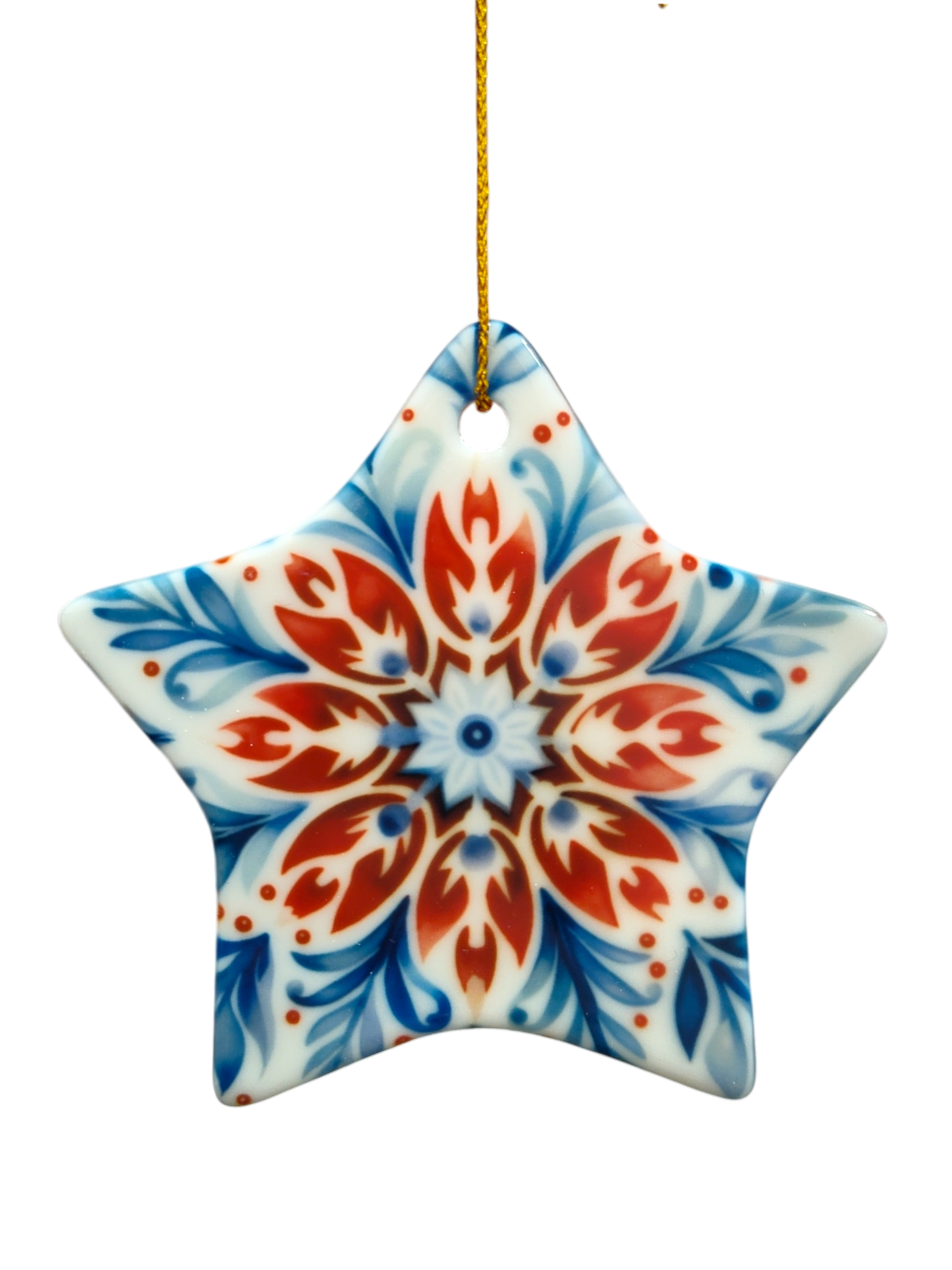 The Ornament: Red, White, and Blue Rosemaling Star Ceramic Ornament features a symmetrical floral pattern in red, blue, and white inspired by Scandinavian rosemaling, and hangs from a gold string.