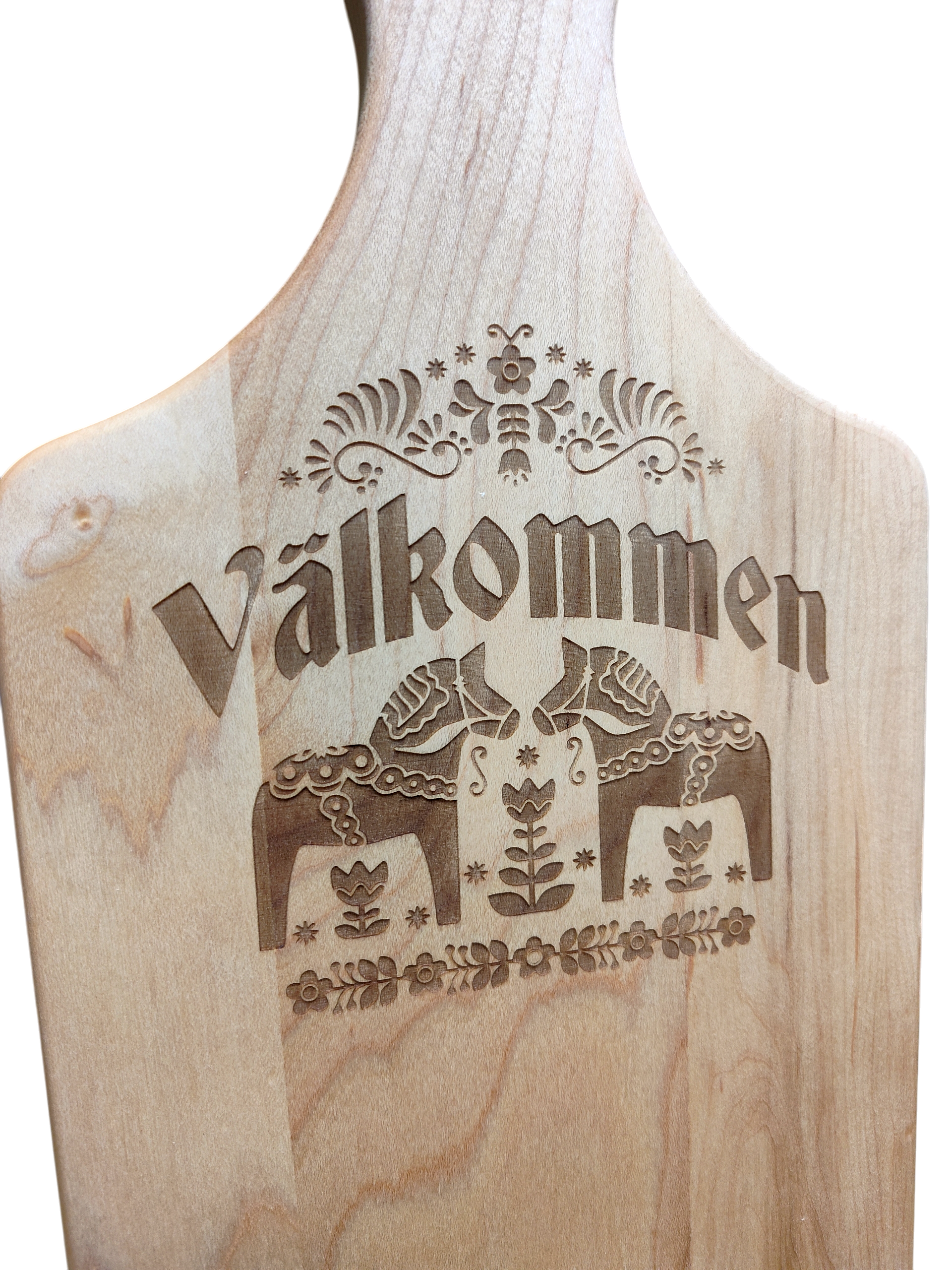 The "Valkommen" Maple Wood Cutting Board (13.5" x 7") features the Swedish word for welcome, two Dala horses, and detailed floral patterns inspired by Swedish folk art.