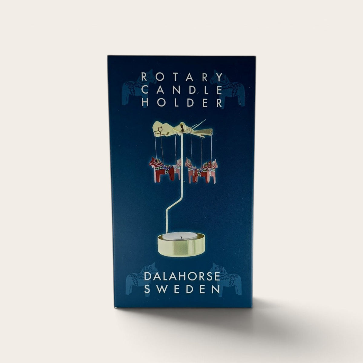 Swedish rotary candle holder in a blue box with a spinning mobile of red Dala horses.