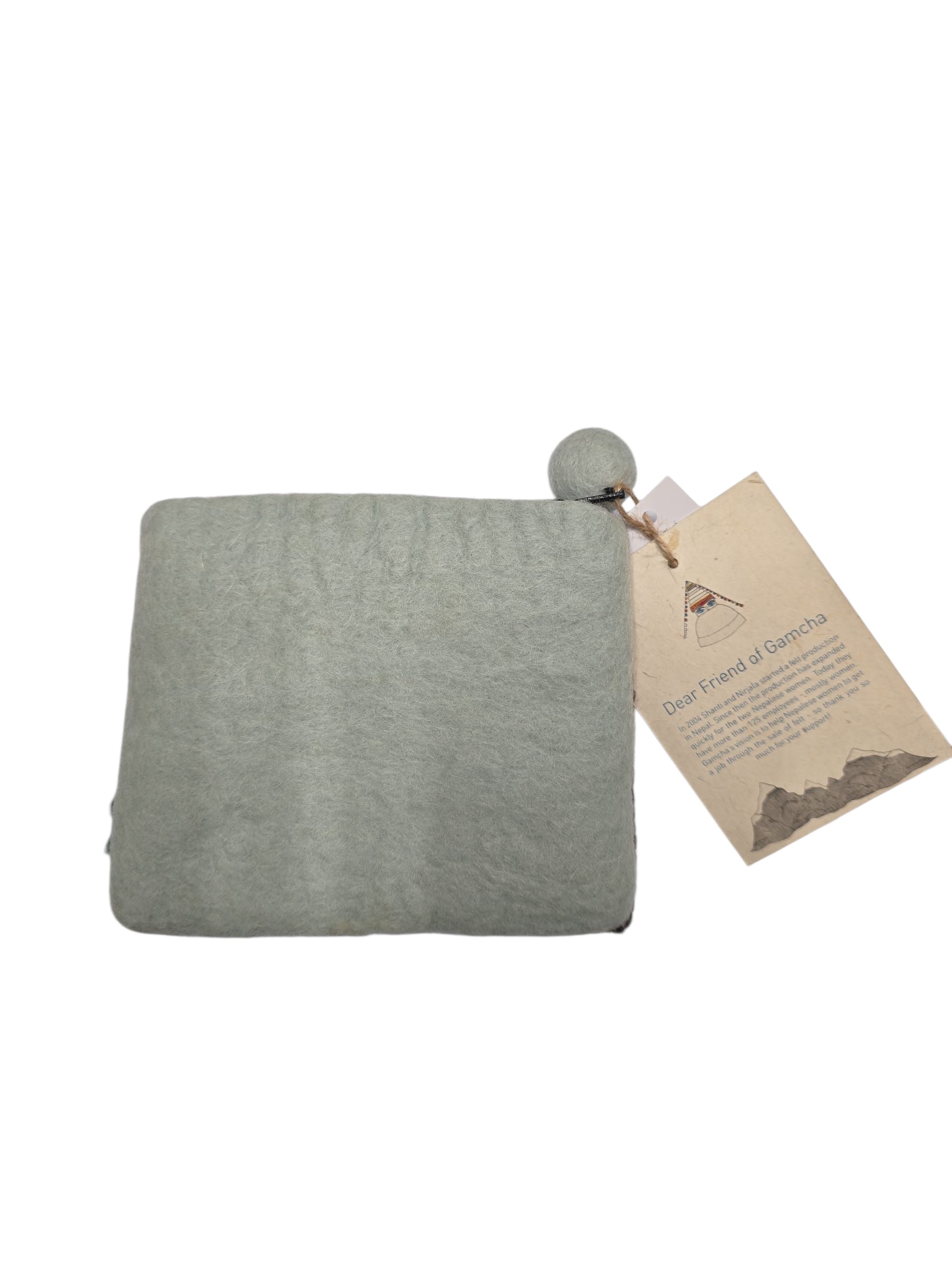 A folded light green wool felt coin purse, 5" x 4.5", features a brown owl on a tree branch, with a pom-pom corner and a brown paper tag—evoking the charm of handcrafted Nepalese accessories.