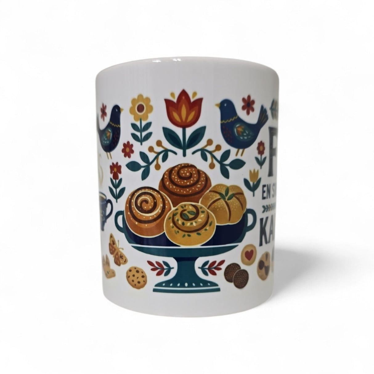 The Swedish Gift Store's "Fika — En Svensk Tradition Kaffepaus" 11oz ceramic mug features colorful folk art with pastries, flowers, leaves, blue birds, and cookies—perfect for a cozy Swedish coffee break.