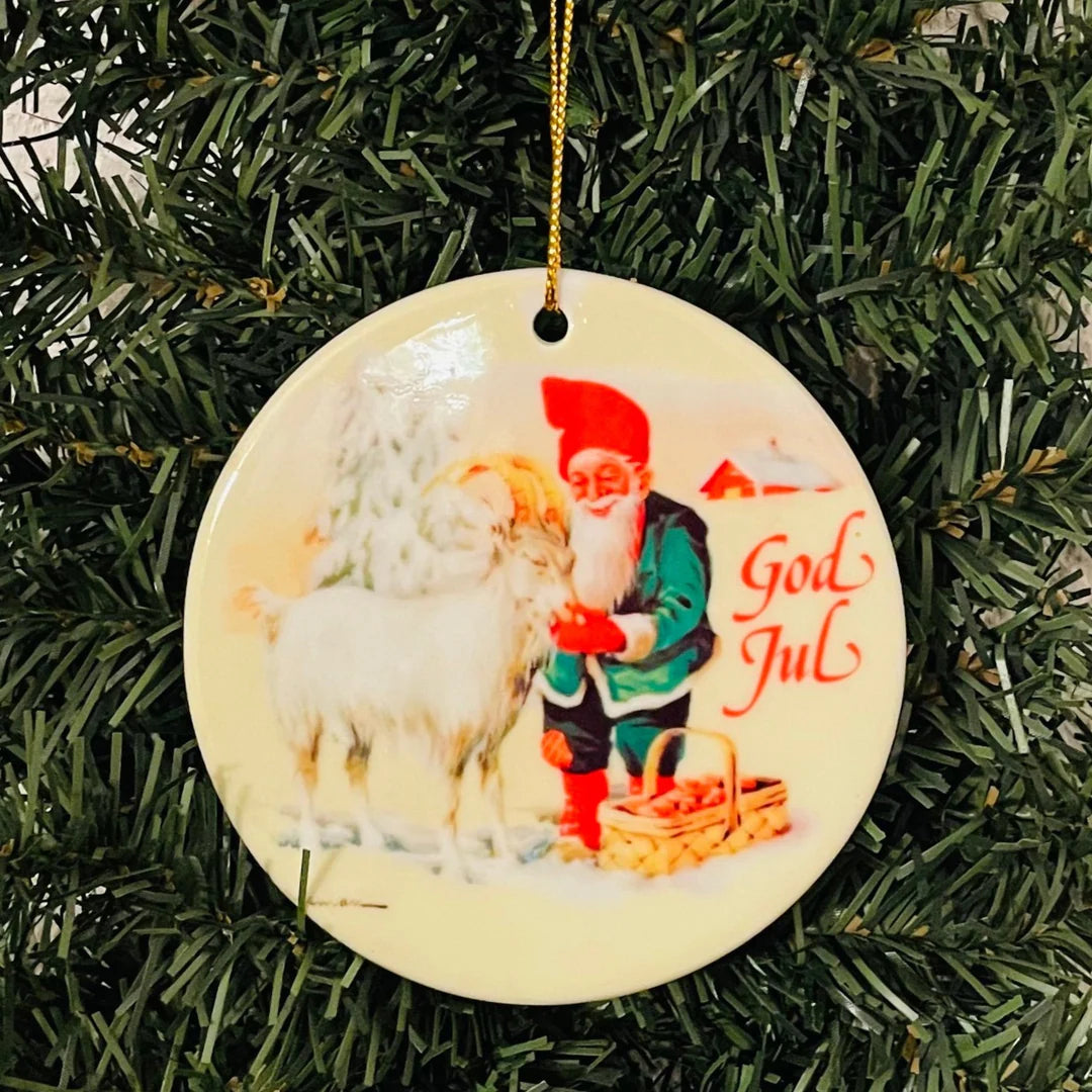 The Ornament: Large Ceramic Ornament, Gnome Tomte with Goat, features a Scandinavian Santa and goat with "God Jul" on a snowy background—perfect as a charming Scandinavian Christmas tree ornament.