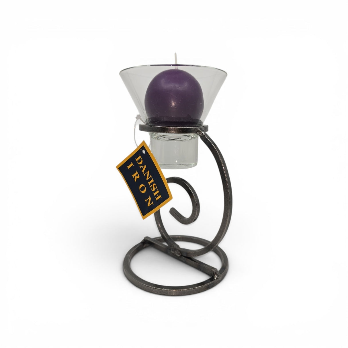 A Talla Imports Candle Holder: Danish Iron with Tall Curl Base holds a purple ball candle in a Leif Cup. The stand features a tag reading "Danish Iron" and is set against a plain white background.