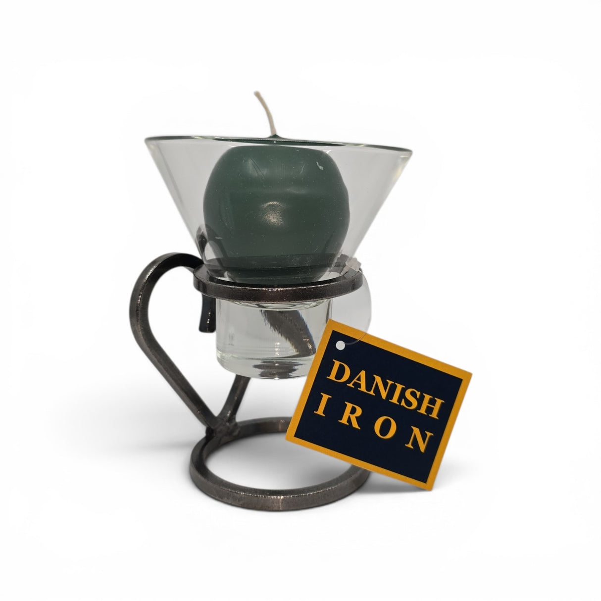 A green candle in a glass holder rests on the Danish Iron Candle Holder with Heart & 1 Leif Cup for Ball Candle from Talla Imports, featuring a yellow and black tag against a white background, showcasing elegant handmade Danish decor.