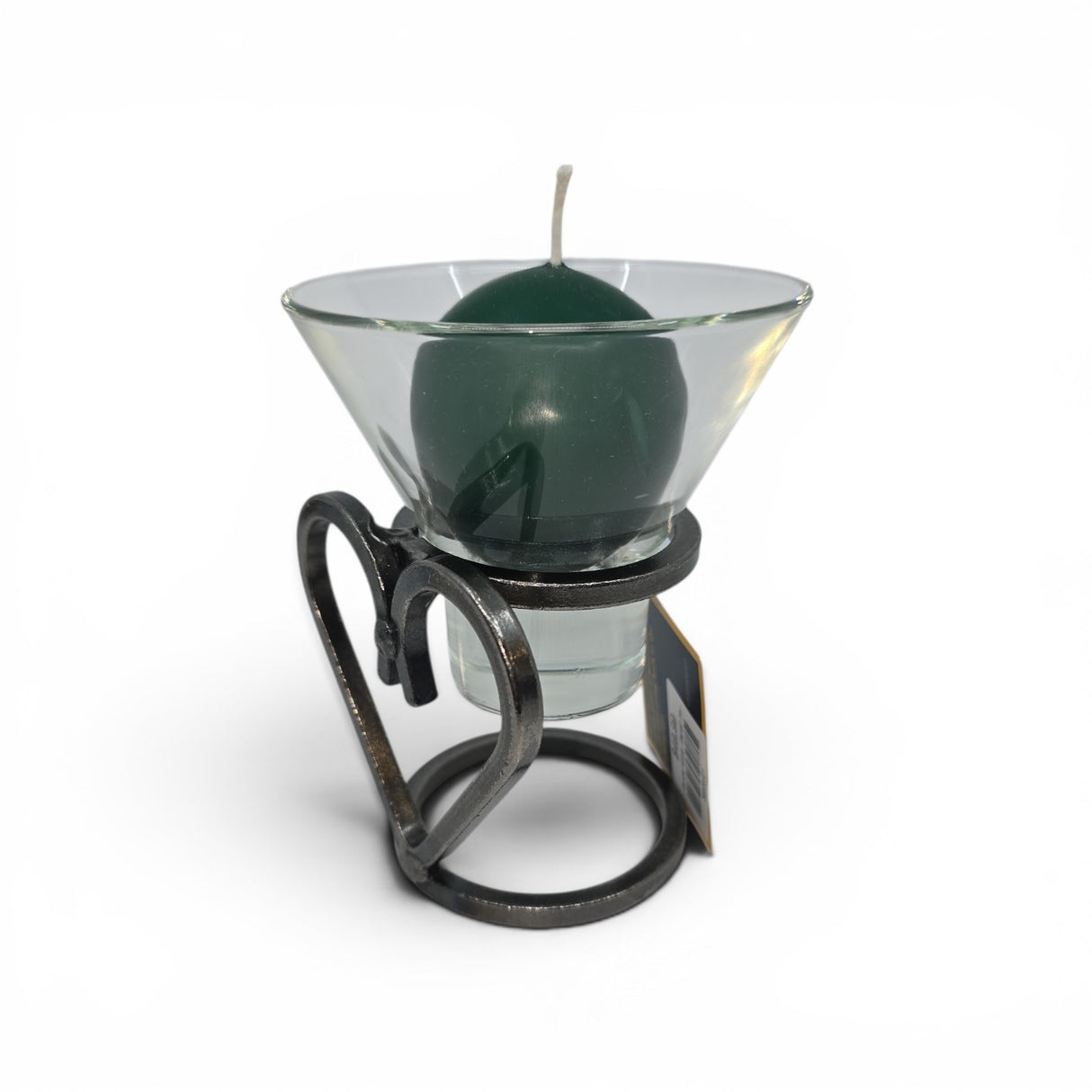 A green round candle in a glass cup sits on the Talla Imports Danish Iron Candle Holder with Heart & 1 Leif Cup, a handmade decor piece featuring a heart design, displayed against a white background.