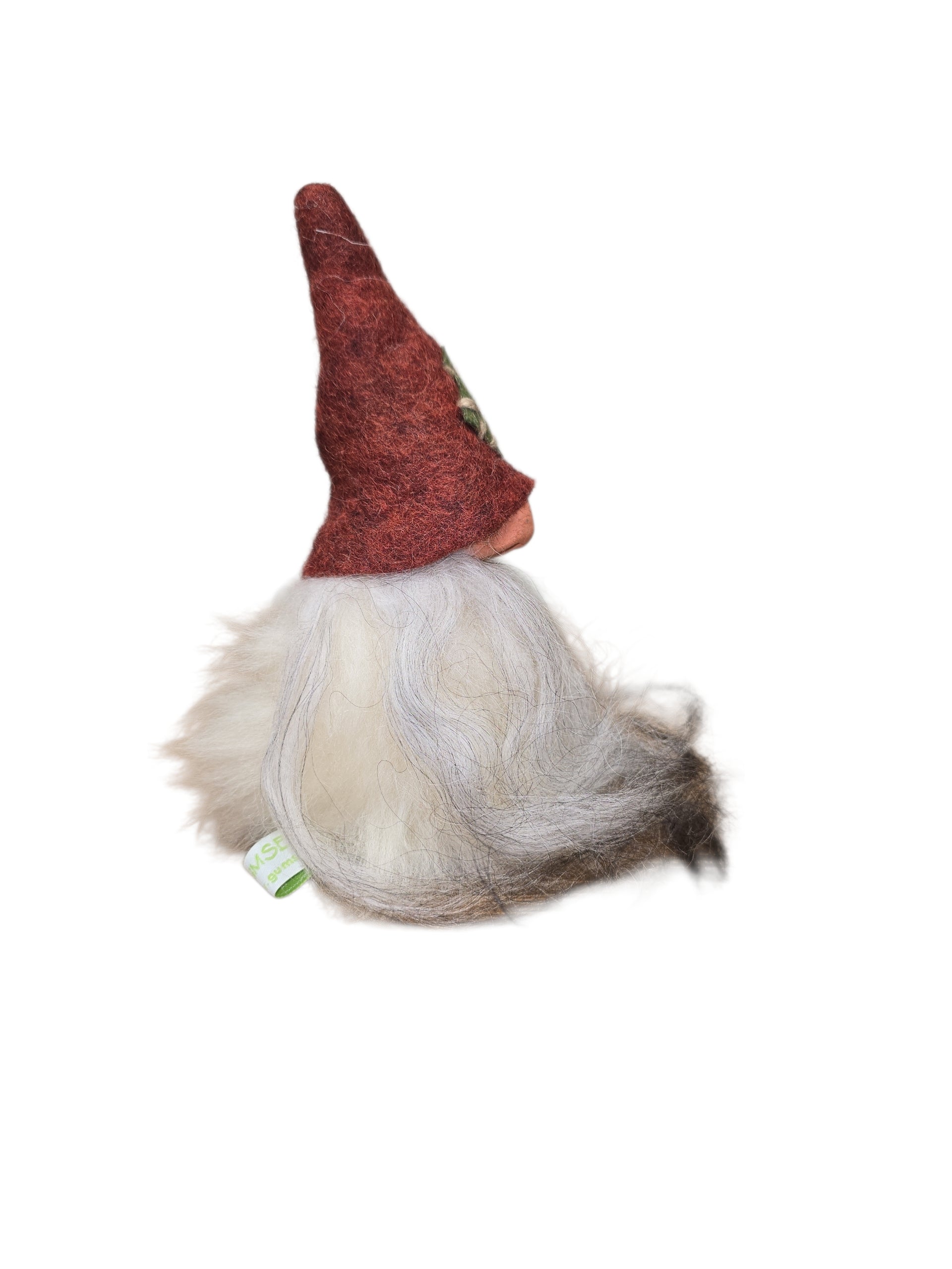 The "Patch Tomte" gnome by Gumselids of Sweden features a long white beard, pointy red hat, and green tag, standing 7" tall on a wood base—ideal as handcrafted Swedish decor made from sheep wool.
