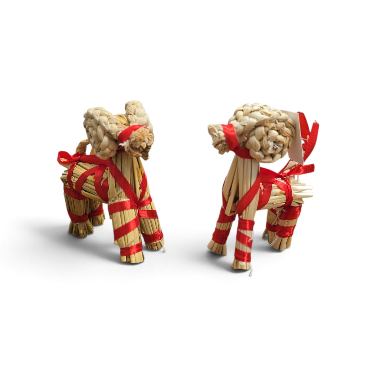Two straw Dala horses and a Swedish Yule goat tied with red ribbon.