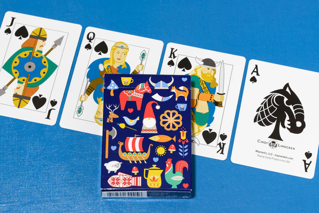 The Playing Cards: Nordic Deck - Poker Size Playing Cards features illustrated face cards (Jack, Queen, King of spades), an Ace of spades with a fish, and a vibrant box with Scandinavian motifs—ideal for Nordic card fans.