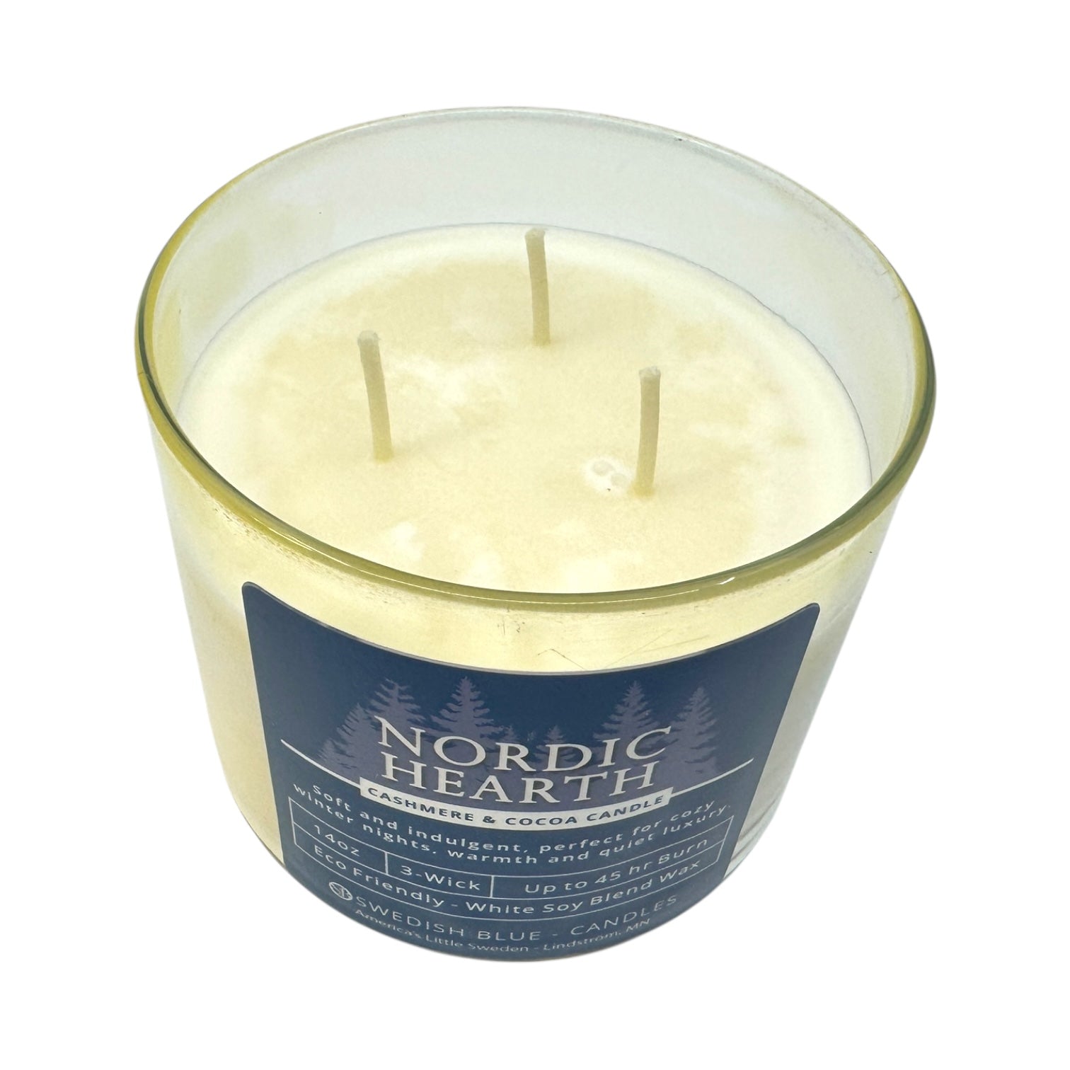The Nordic Hearth Cashmere & Cocoa Candle, 14 oz, features a white soy blend wax in a glass jar with three wicks. Its cozy scent and elegant design make this 3-wick candle a perfect addition to any space.