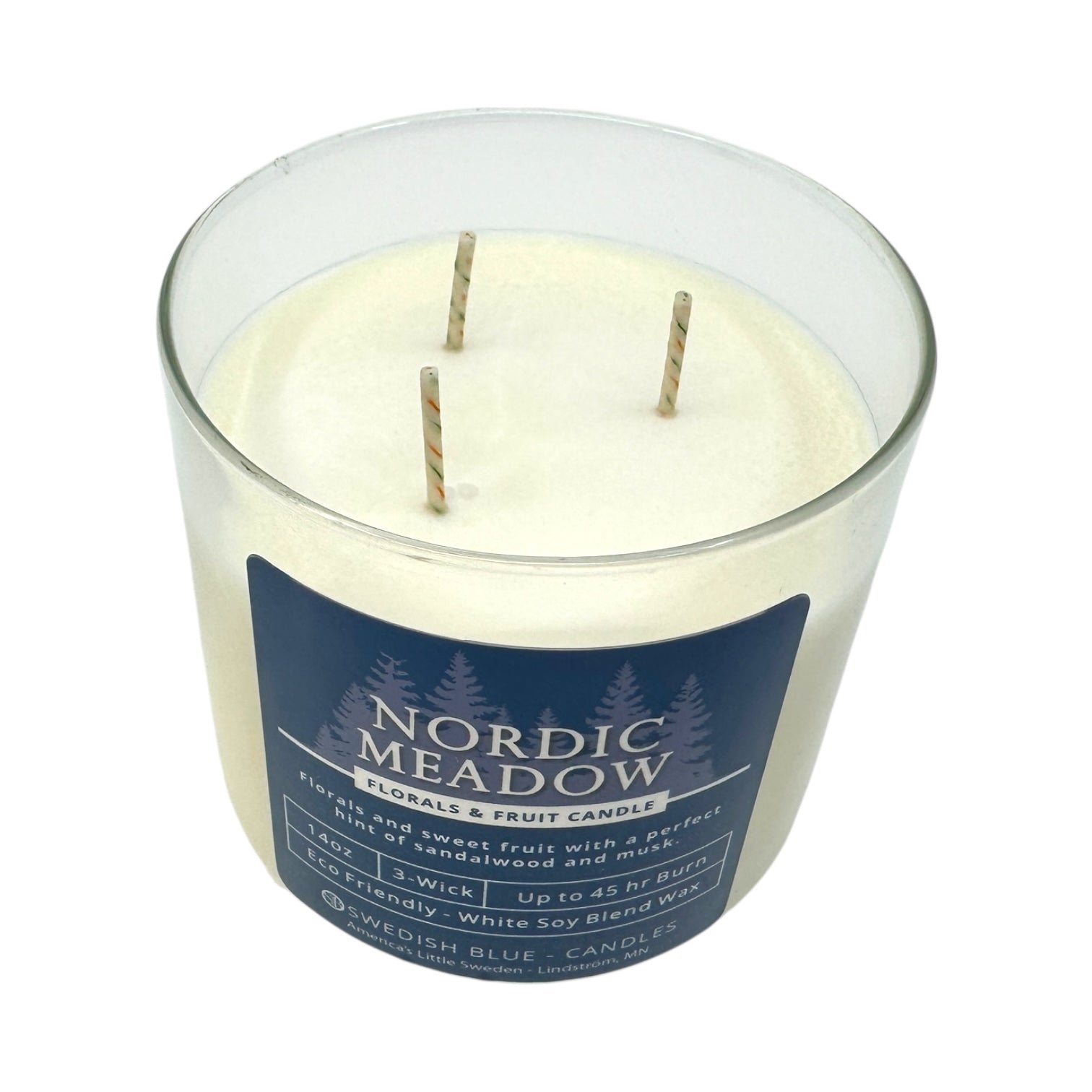 The Nordic Meadow – Florals & Fruit Candle is a 14 oz glass soy blend candle with three wicks and white wax, featuring fresh floral and fruit scents.