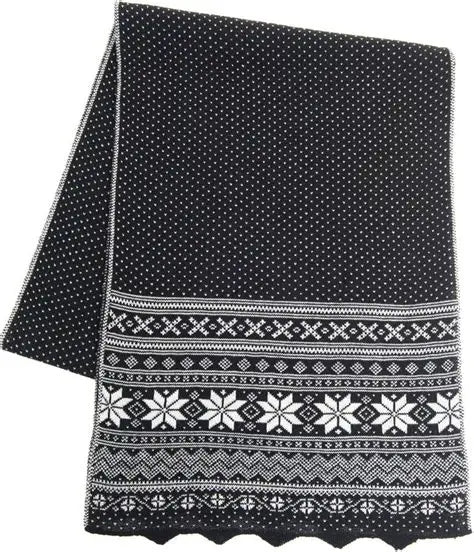 The Northern Story Setesdal Black Scarf is crafted from 100% merino wool in blue, featuring soft knit, white dotted designs, the classic Selbu star pattern, and a scalloped edge for a Nordic-inspired look.
