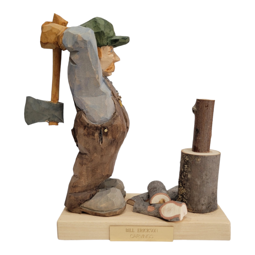 The Woodchopper figurine by Bill Erickson features a hand-carved lumberjack ready to swing his axe, elegantly standing on a base marked with Bill Erickson Carvings, exemplifying fine artisanal craftsmanship.