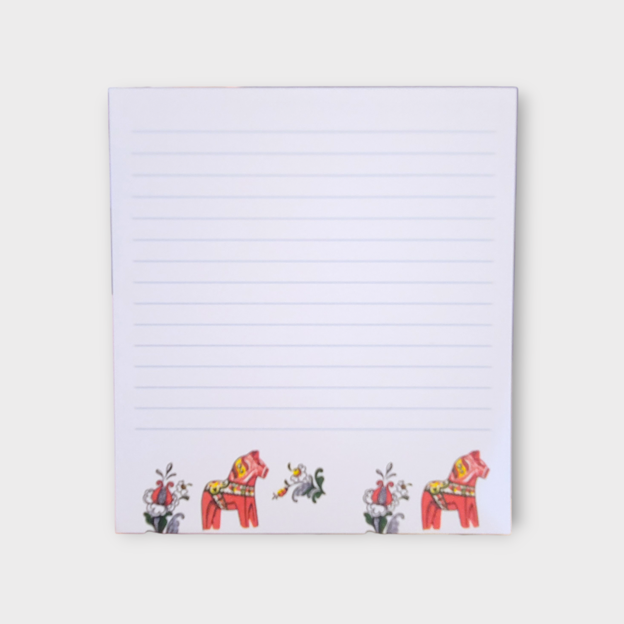 Tablet notepad with lined paper, featuring red Swedish Dala horses and floral decorations at the bottom. 100 sheets. Made in Sweden.