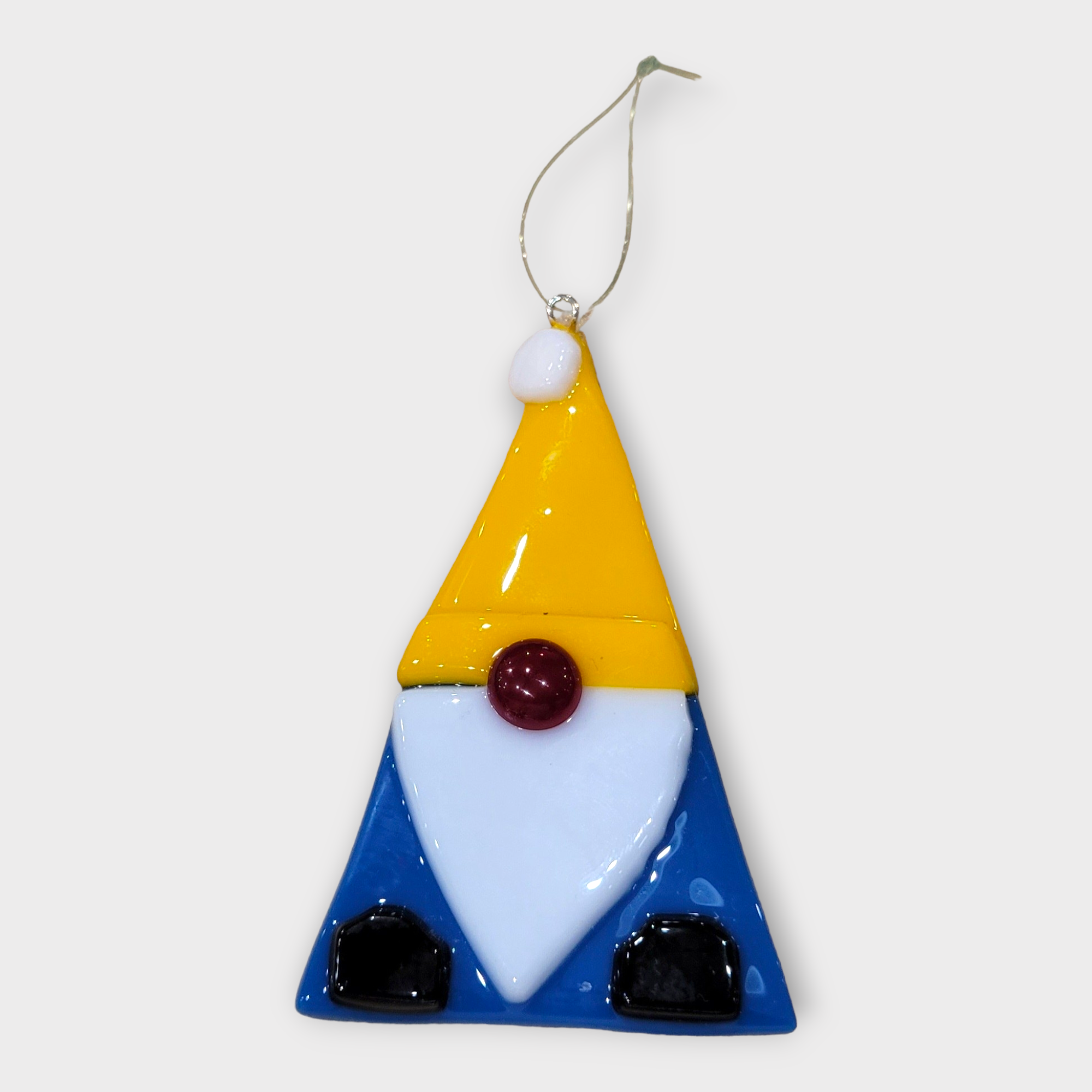 The Ornament: Glass Gnome Christmas Tree Ornaments (3" high x 2" wide) features a gnome with a yellow hat, white beard, blue body, and black feet hanging by a gold string—ideal for adding Scandinavian charm to your Christmas tree.