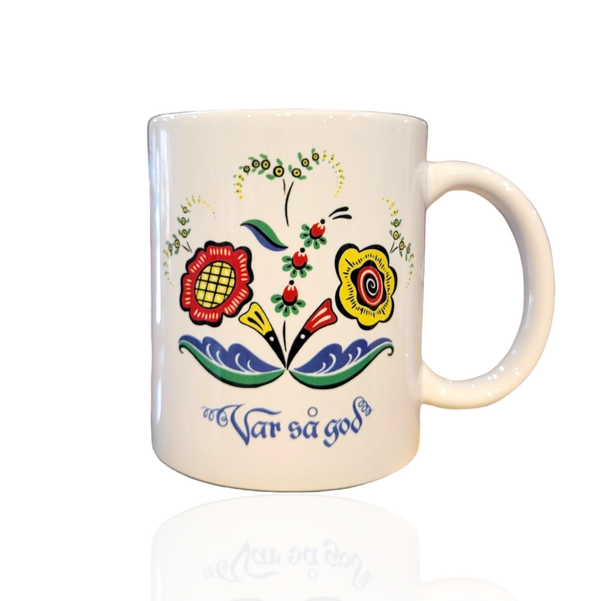Enjoy your favorite drink in the Var så god Mug – Swedish Floral Design (11oz), a white ceramic mug featuring a colorful Scandinavian-style floral pattern and the phrase Var så god in blue script, honoring Swedish hospitality.