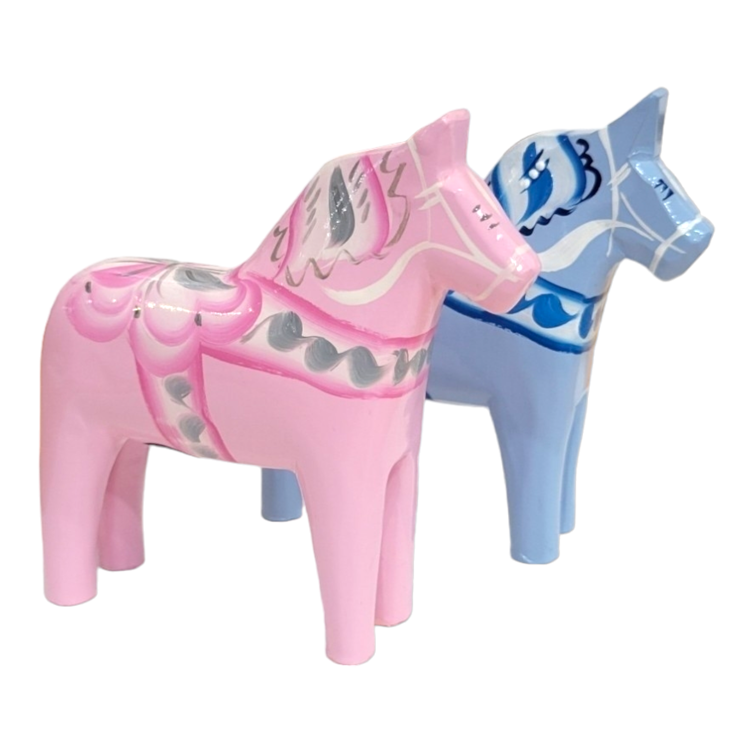 Two Dala horses, a baby pink one with gray and pink details and a baby blue one with white and blue accents, stand side by side. Each showcases the artistry of Swedish traditional hand carving and painting.