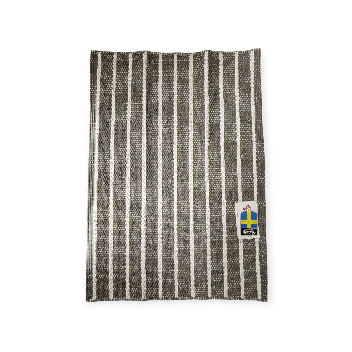 A woven vinyl rug named Horredsmattan - Music - Dark Gray featuring black and white stripes and a tag with the Swedish flag.