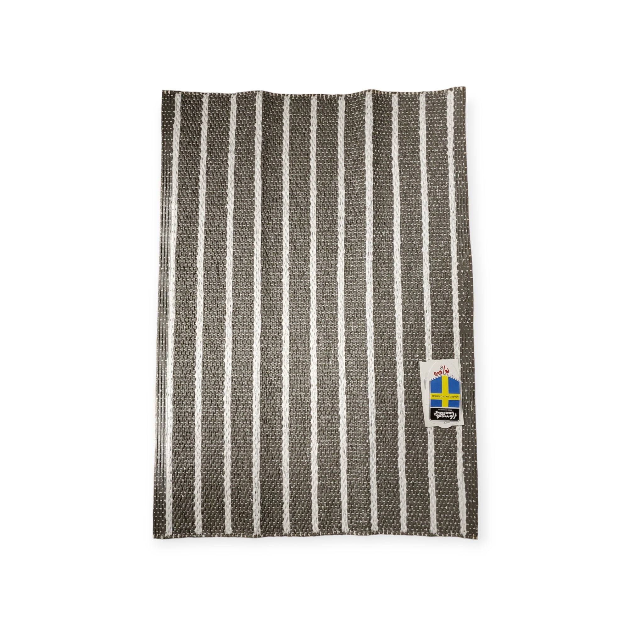 A woven vinyl rug named Horredsmattan - Music - Dark Gray featuring black and white stripes and a tag with the Swedish flag.