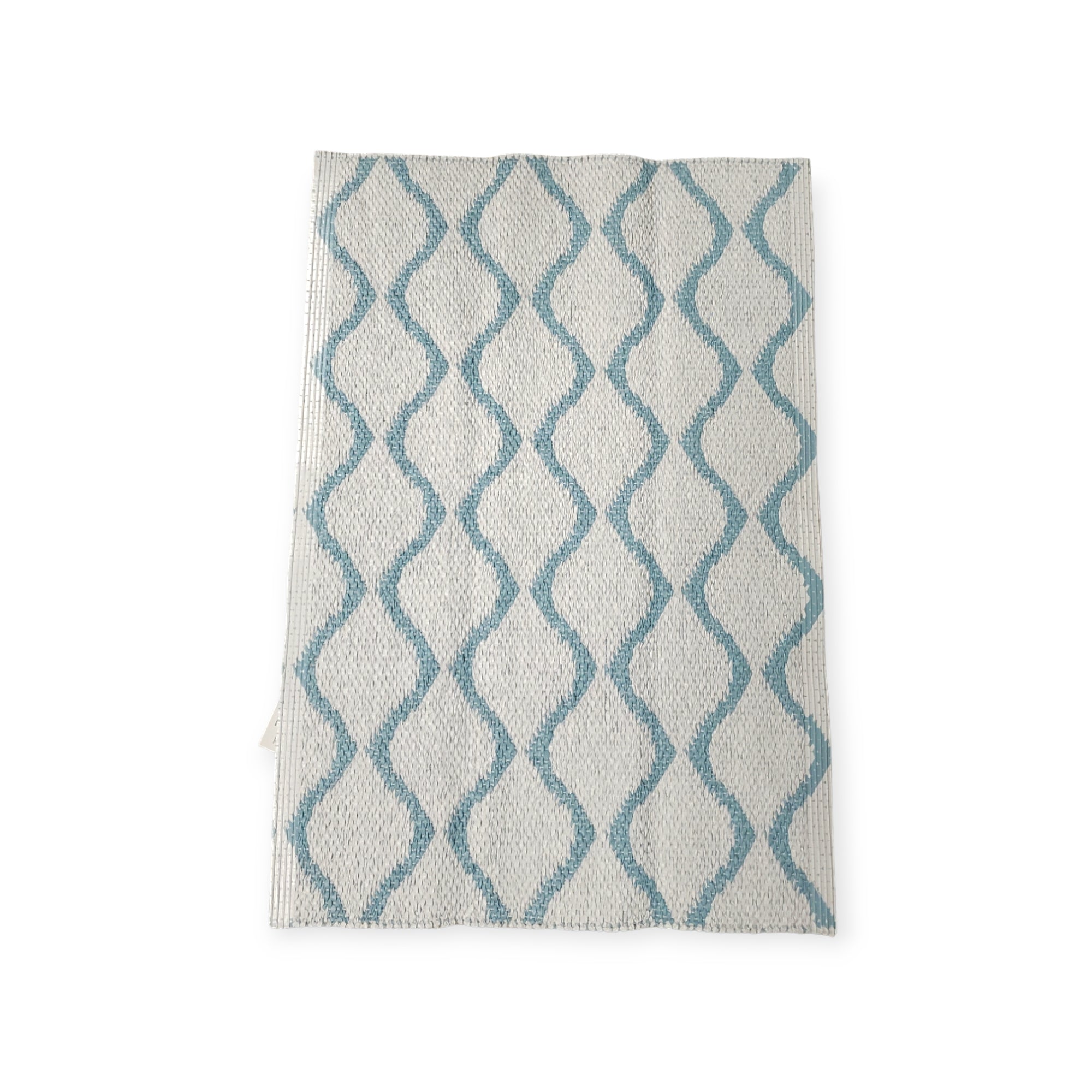 The Rug: Wave Blue is a white kitchen towel that boasts a blue wavy line pattern, ensuring both durability and longevity.