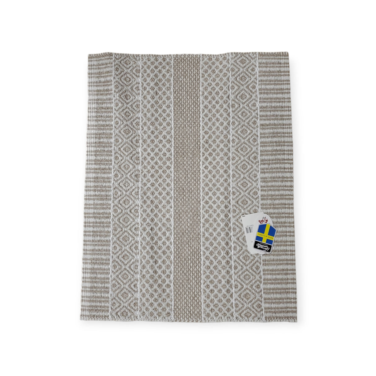 The Vinyl Rug: Horredsmattan - Alfie - Sand is a gray and white patterned Swedish rug with a woven design, lying flat with a tag attached, showcasing its environmentally friendly PVC composition.