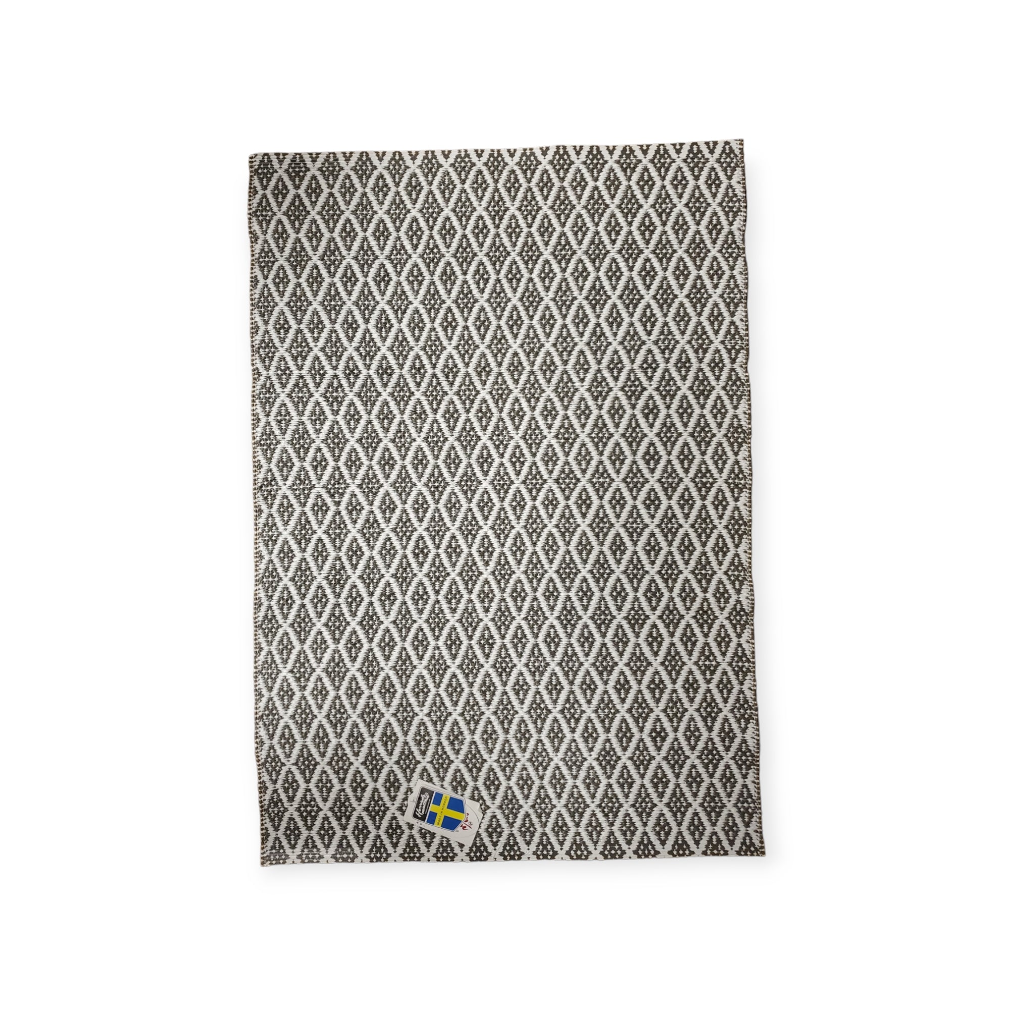The Eye Grey 70x100cm features a black and white design with diamond shapes. This Swedish vinyl rug boasts a non-skid reversible feature and includes a small Swedish flag tag in the corner. Its durability and longevity make it a stylish addition, adding elegance to any room.