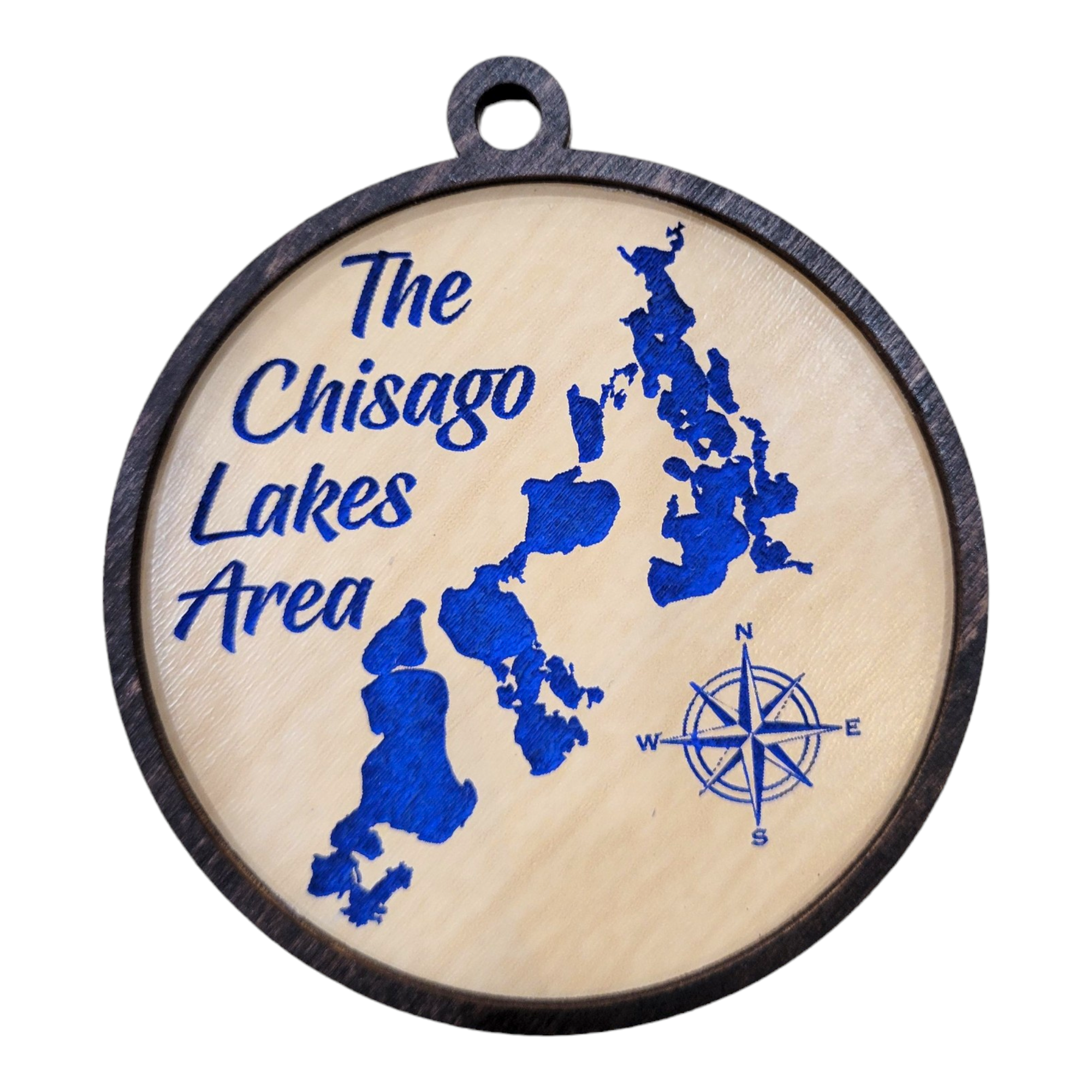 A round etched wood ornament featuring a blue map of the charming Chisago Lakes Area, elegantly adorned with a compass design—a perfect keepsake for explorers.