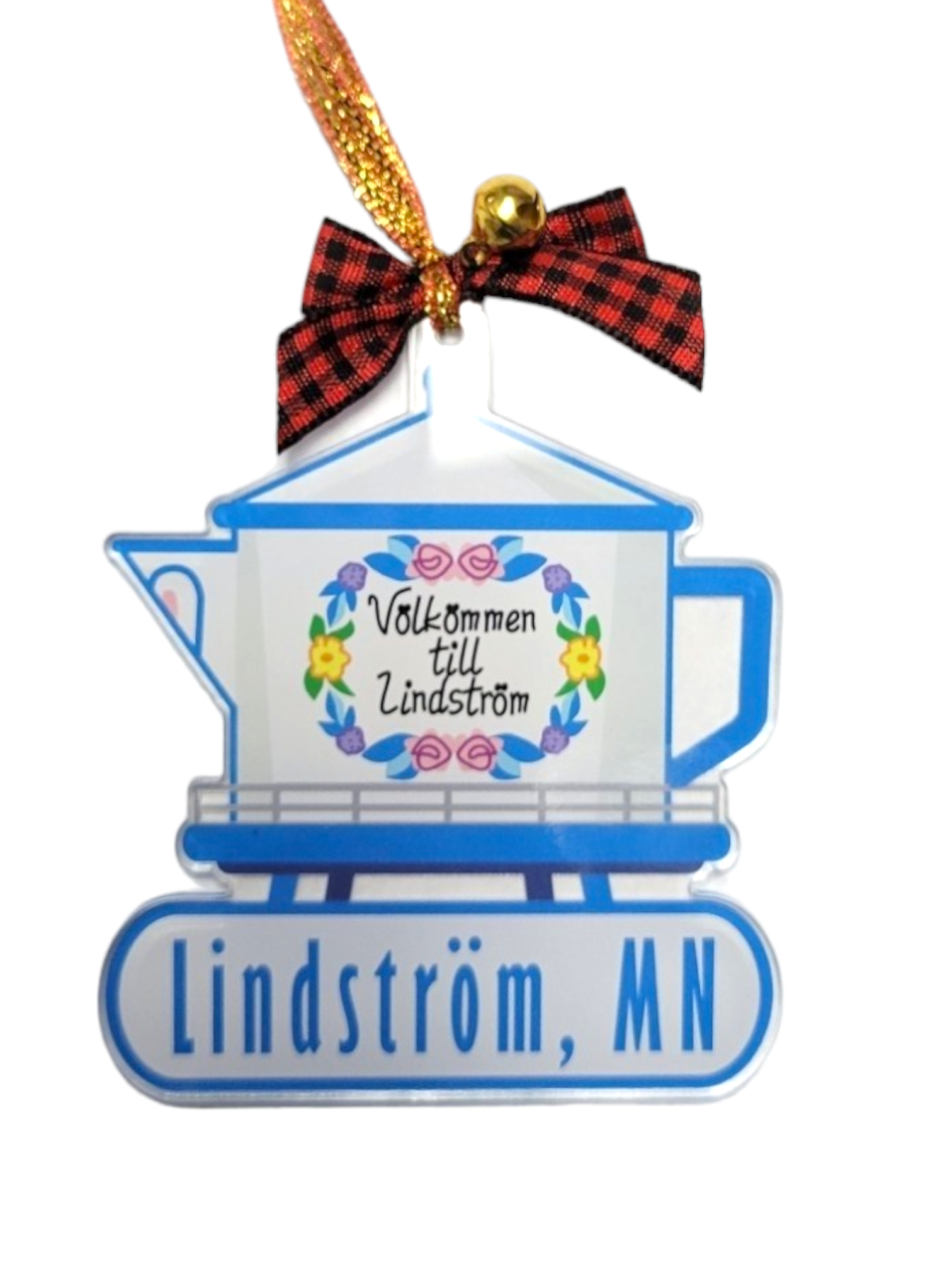 The Ornament: Lindstrom Water Tower Color is an acrylic ornament, 3" tall by 2.75" wide, shaped like a blue coffeepot with a red plaid bow, gold bell, and a sign that reads “Välkommen till Lindström.”.