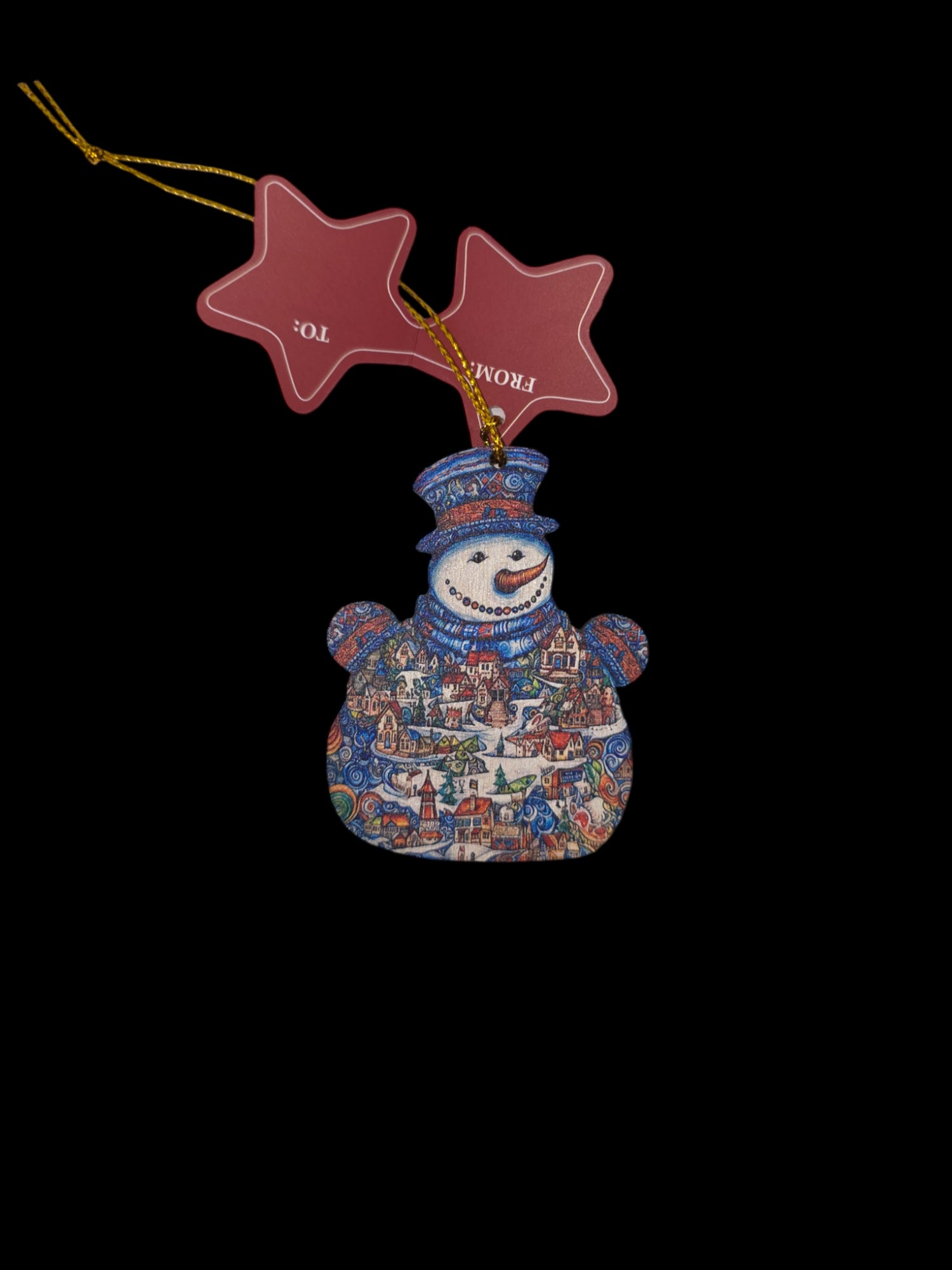 The "Christmas Handcrafted Ornament Scandinavian Snowman D.Gelsinger" by G.DeBrekht Artistic Studios is a high-quality plywood ornament, showcasing a festive village design and accompanied by a gold string with star-shaped gift tags labeled To and From.