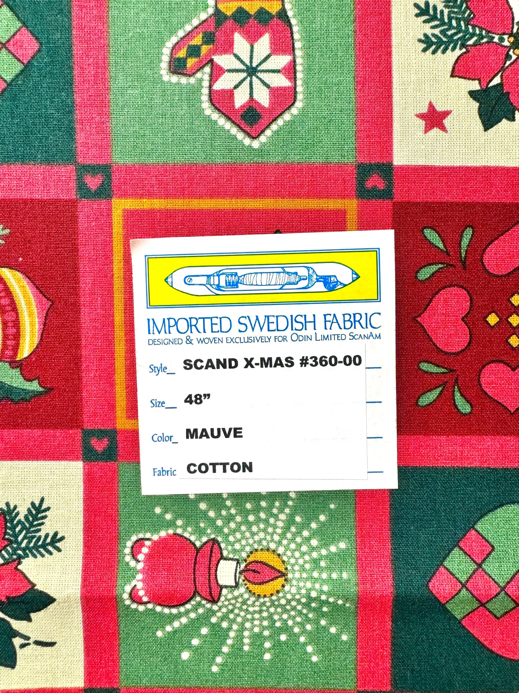 A label on holiday-themed fabric reads: Runner: Scandinavian Christmas Table Runner 48" Long, Style Scand X-Mas #360-00, Color Mauve, Cotton—perfect for festive table decor.