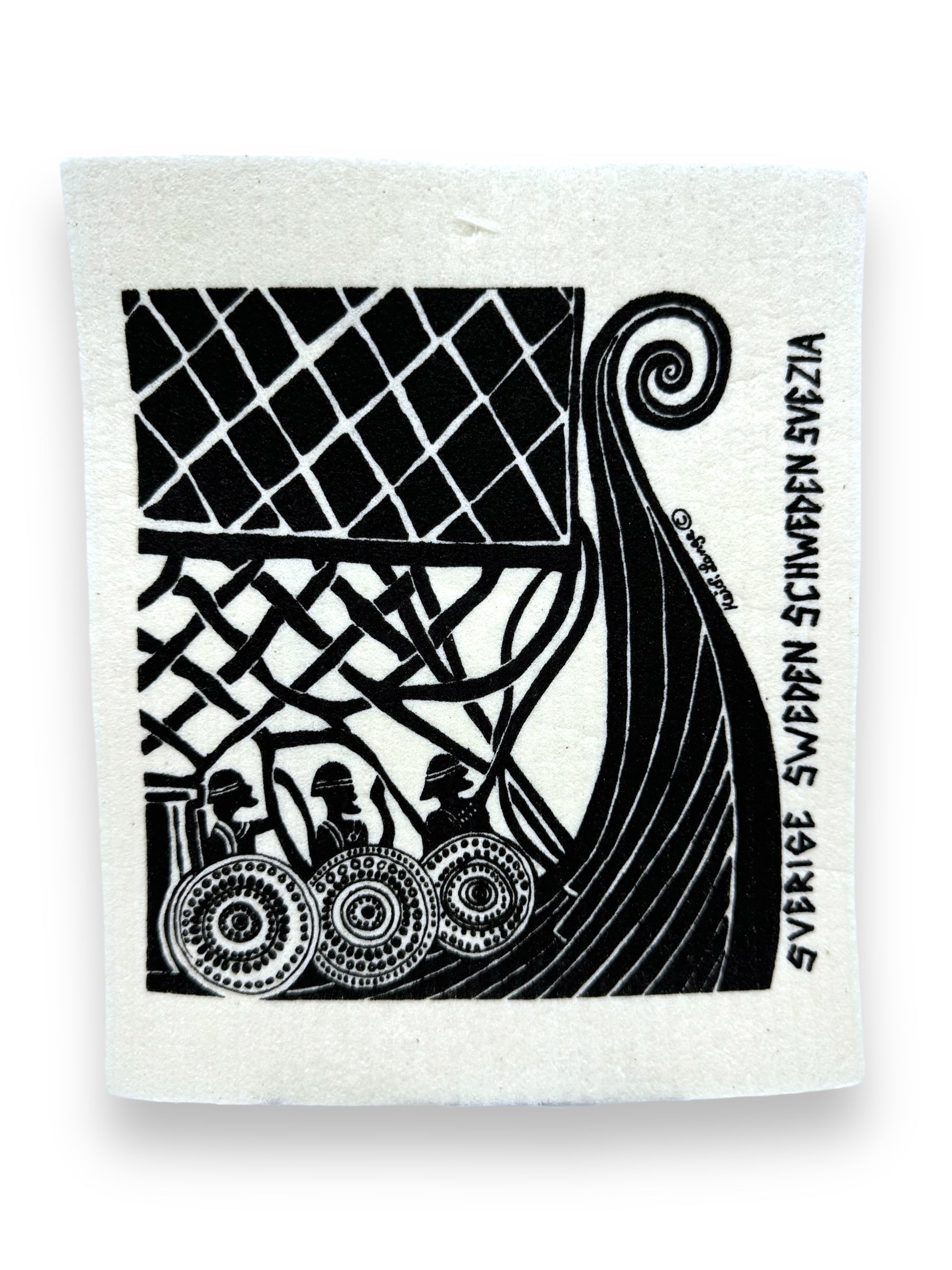 A black and white dish cloth illustration titled "Leif Ericksson Viking Ship" by Heidi Lange showcases a Viking ship with Leif Ericksson, a decorative sail, and three warriors holding shields. The cloth is adorned with text that reads Sverige Sweden Schweden Suecia along the side.