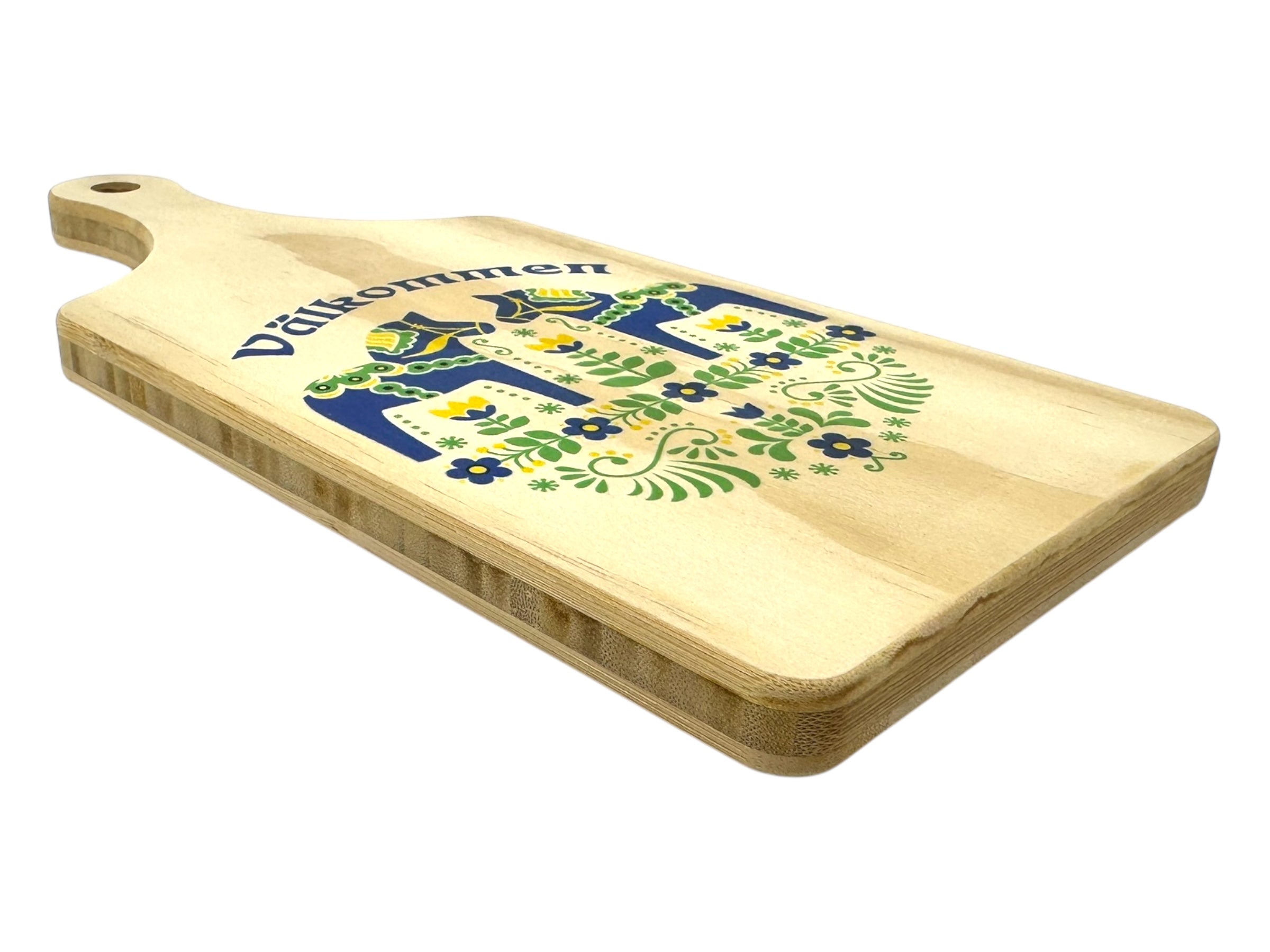 The Välkommen Bamboo Blue Dala Horse Cutting Board features a vibrant Scandinavian design with a blue Dala Horse and the word Välkommen printed on it.