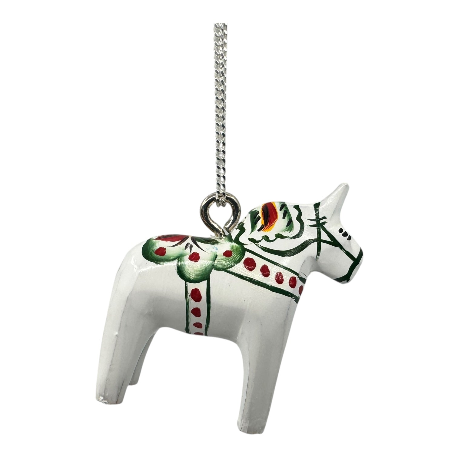 The White Dala Horse Necklace features green and red Swedish folk art patterns on painted wood (2cm pendant) with a 19 handcrafted sterling silver chain.