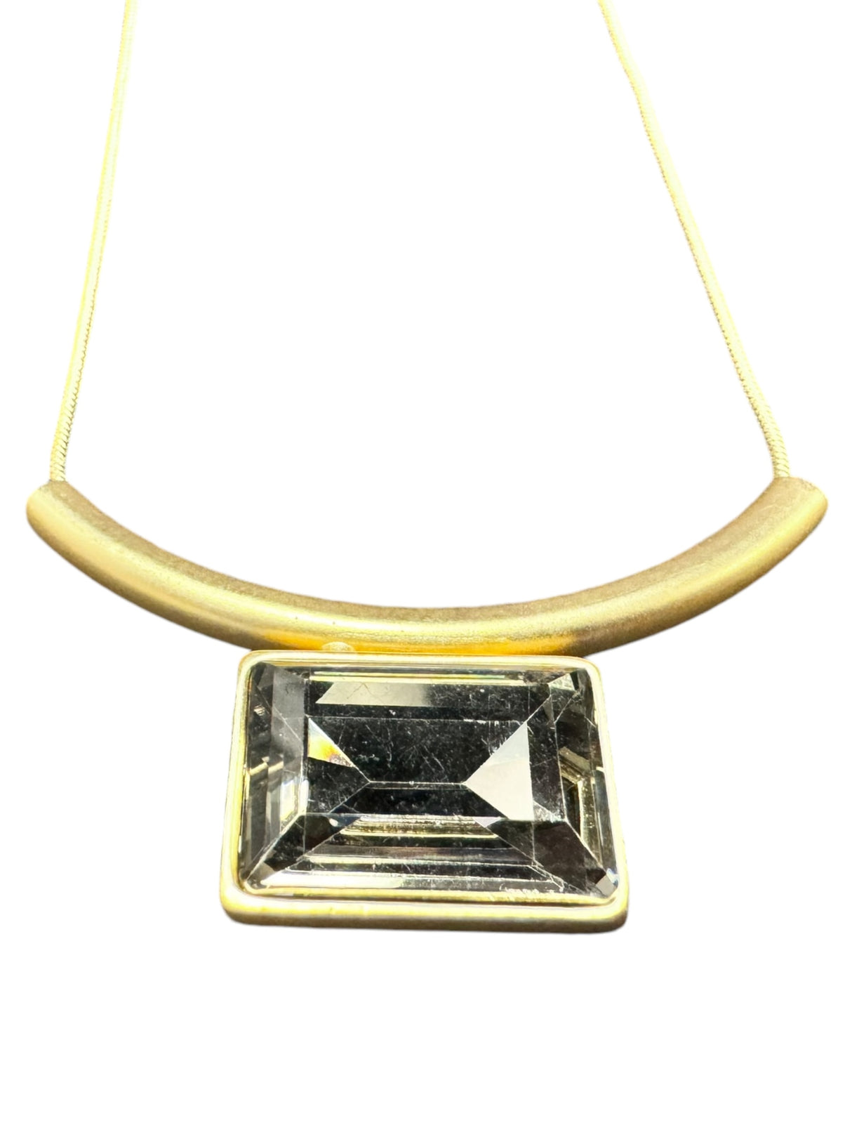 The Audrey Black Diamond Gold Plated Necklace by DANSK Copenhagen features a rectangular gemstone pendant set in gold, hanging from a thin gold chain. Its Nordic design embodies minimalist jewelry and enhances any ensemble.