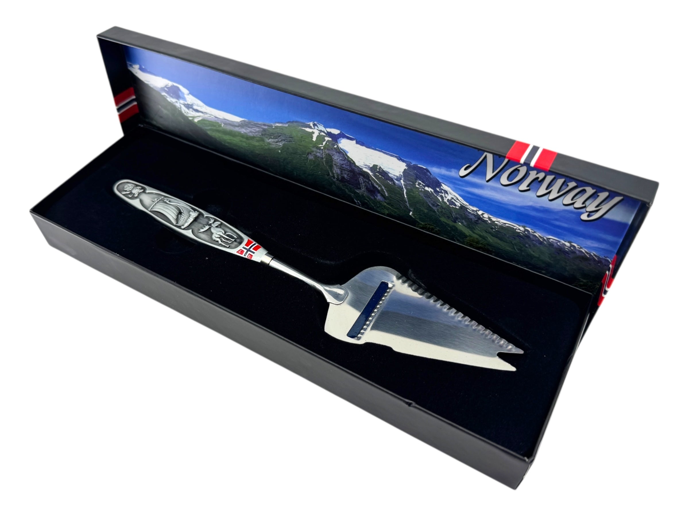A jagged Norwegian cheese slicer & cutter with a pewter handle featuring a Viking ship and moose image, presented in a box—a tribute to Scandinavian heritage.