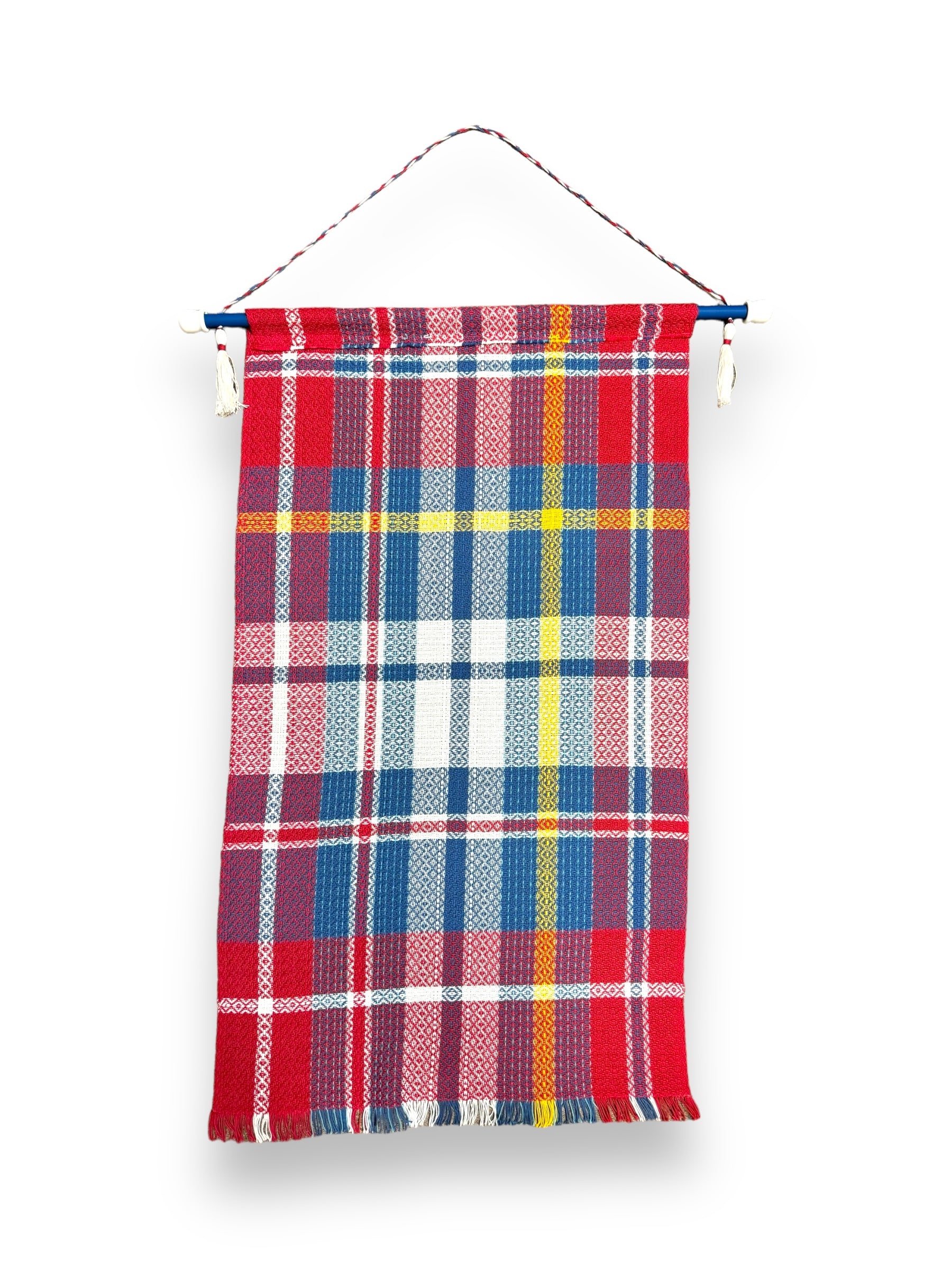 The Flag: Scandinavian Flags on Hanger (39"x22") features a red, blue, yellow, and white plaid pattern, hand woven from 100% cotton. It hangs from a blue rod with a red and white twisted cord against a white background.