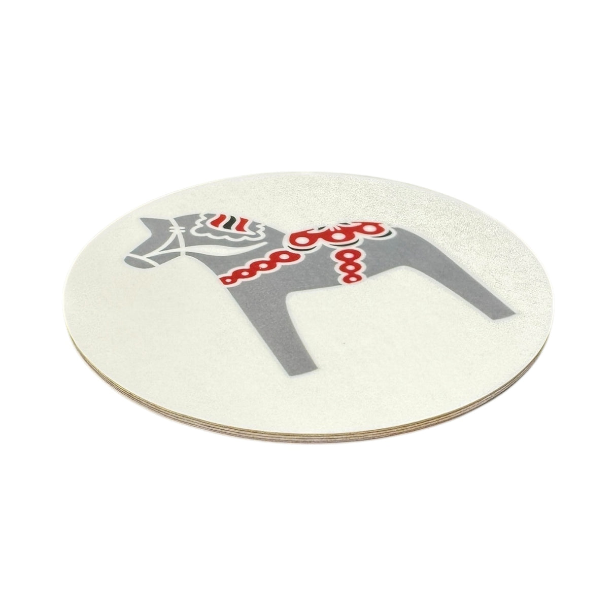 The 3.5 round Dala Horse Coaster features a gray horse with red and white patterns on a white background, adding Scandinavian charm to your decor. Made in Sweden and available in black, blue, red, or grey.