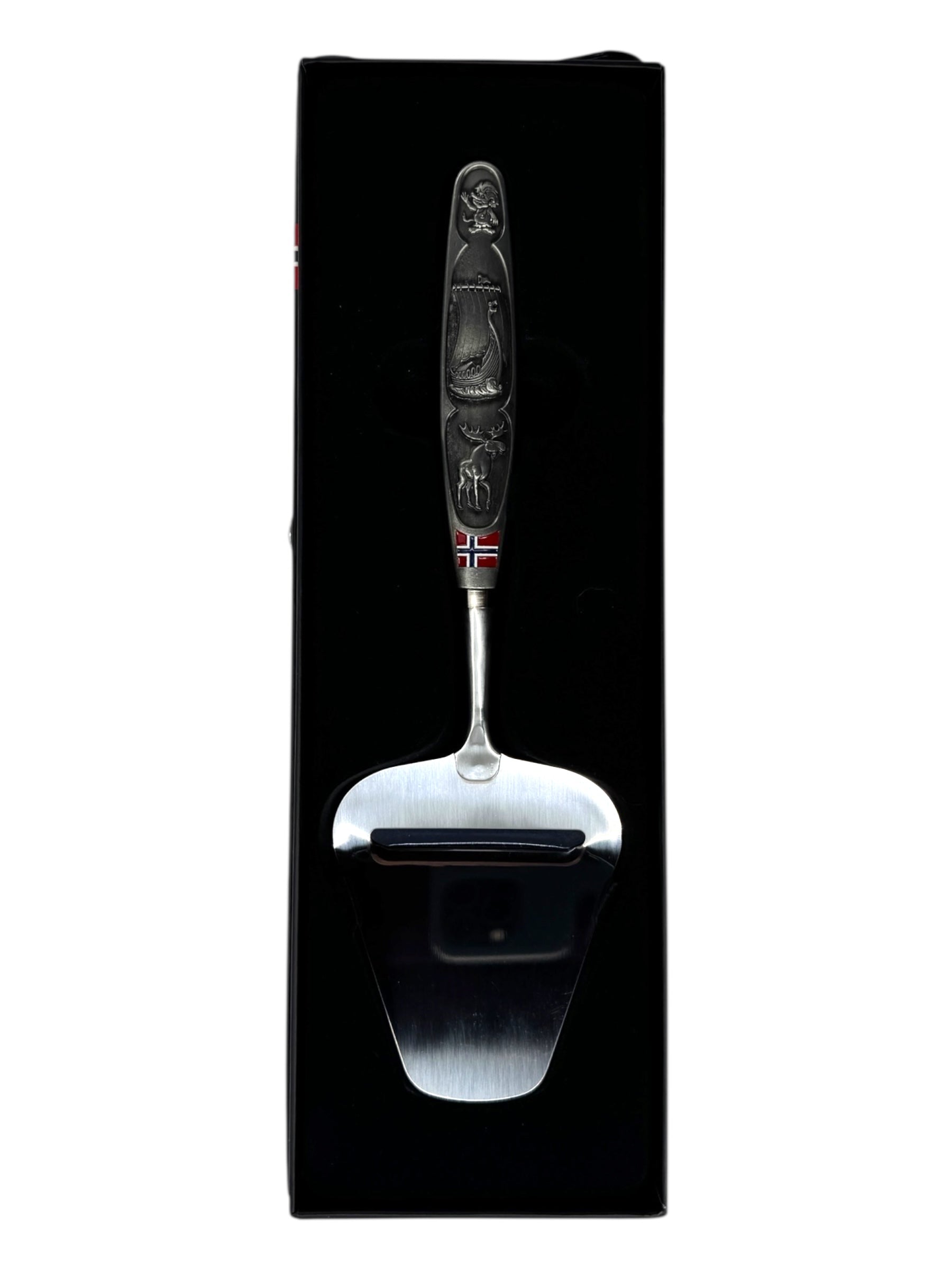 A smooth Norwegian cheese slicer with a pewter handle featuring images of a Viking ship and moose, reflecting Nordic heritage, beautifully presented in a black box.