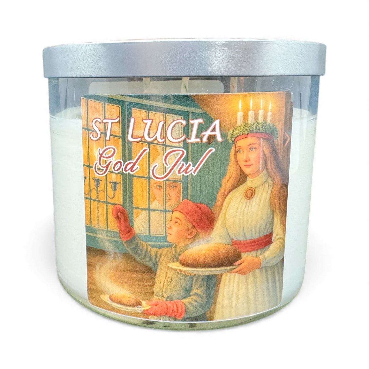 A 14oz Nordic Meadow Candle—florals & fruit blend, 3 wicks, 45-hour burn—in a clear glass jar with silver lid. Features St. Lucia in white robes with candles and a child holding bread, plus “ST LUCIA God Jul” on the label for festive warmth.