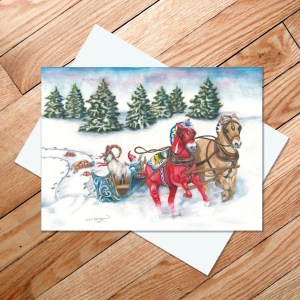 The Runaway Sleigh 5x7 card by Rachael Koppendrayer features two Norwegian Fjord horses pulling a sleigh through snowy trees, displayed on a wooden surface.