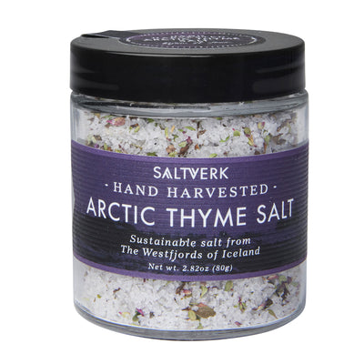 A Saltverk 4-Flavor Gift Box includes flaky Icelandic sea salts—Lava, Birch Smoked, Arctic Thyme, and classic—in clear jars with purple and black labels highlighting their Icelandic origin. Total net weight: 4 x 2.82 oz (80g).