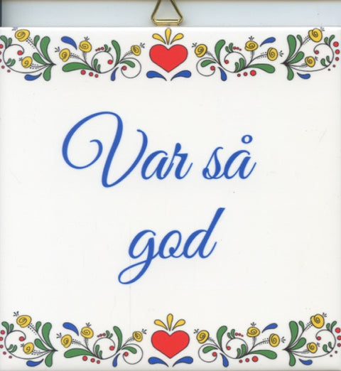 The 6" ceramic tile, "Var sa God Susan Swanson Swartz," showcases floral patterns and the Swedish phrase in sophisticated blue script, making it an ideal piece of wall art.
