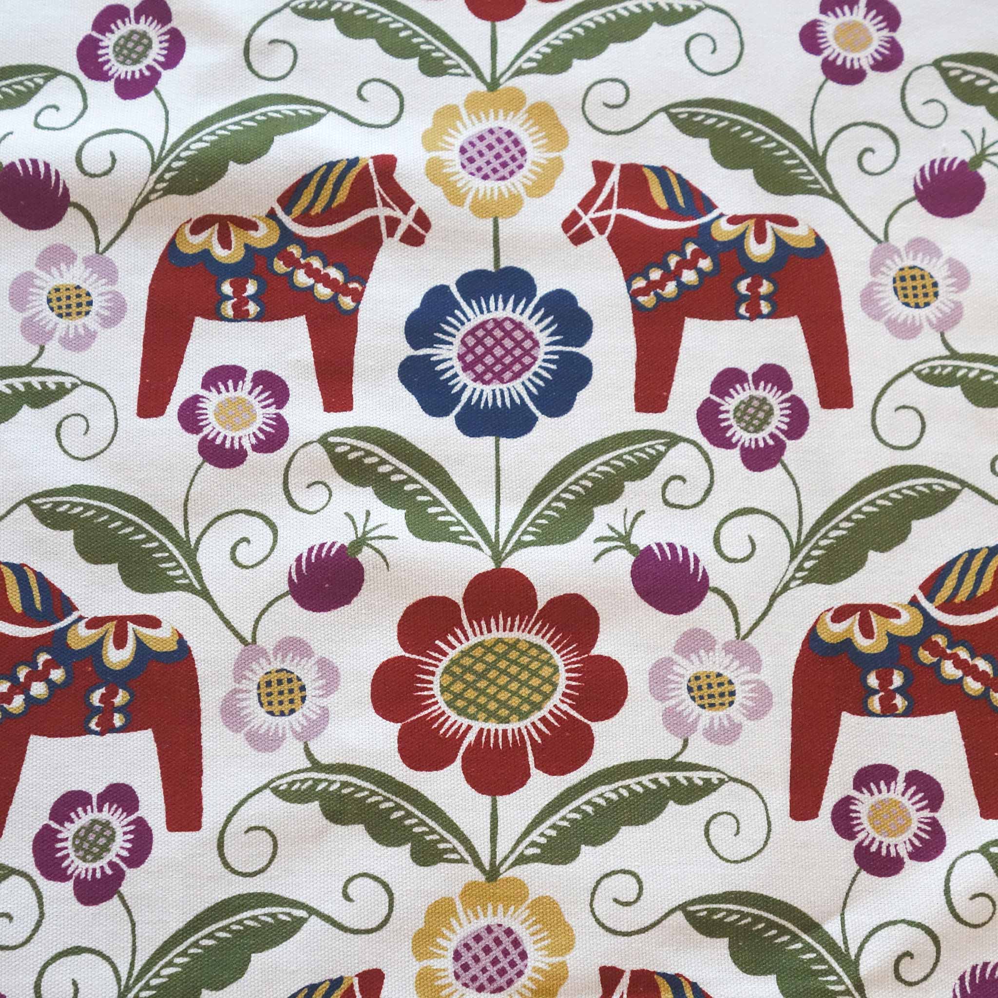 Discover the Siljan Towel, a Dala-inspired design featuring colorful Scandinavian folk art with Dala horses, vibrant flowers, and lush green leaves on a light background. This eco-textile brings charm and tradition to your home.