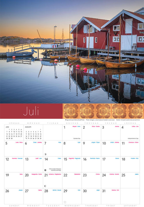 The July page of the Splendor of Sweden Calendar 2026 shows a sunset waterfront with red wooden houses, boats, and a dock; dates and Swedish holidays are listed beneath the image.