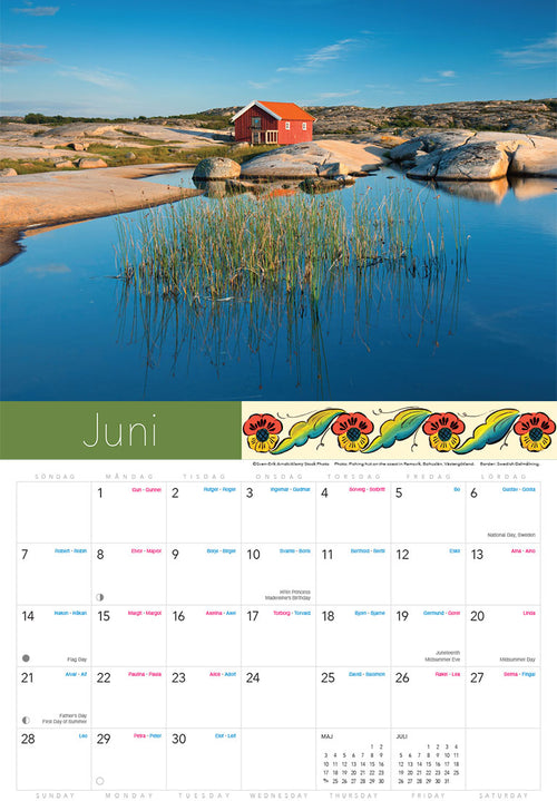 A red house on rocky shores beside calm water and reeds under a blue sky is featured for June in the Splendor of Sweden Calendar 2026.