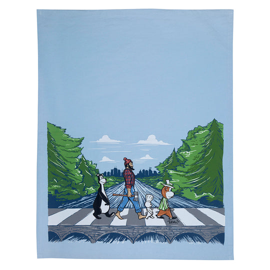 This vibrant illustration by Adam Turman adorns the "Tea Towel: MN Abbey Road," showcasing four dog-like characters strolling across a forest road in a nod to the iconic Abbey Road scene. This beautifully captured image is printed on a machine washable cotton towel, making it an ideal creative addition to any home.