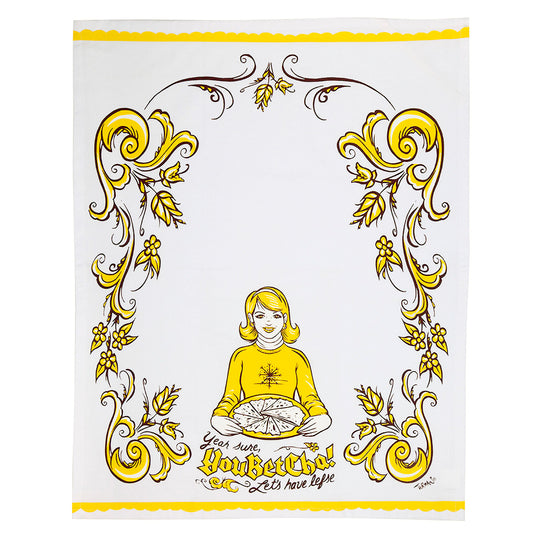 Illustration by Adam Turman on a cotton tea towel features a person in yellow with a pie, surrounded by floral motifs. Text reads: Yeah, Sure, You Betcha! Lets have Lefse!.