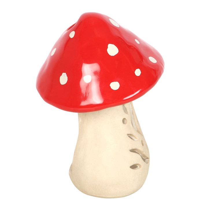 The Candle Holder: Mushroom Tealight Candle Holder is a 6 tall ceramic piece with a red, white-spotted cap and beige stem, ideal for adding cottagecore charm to any space.